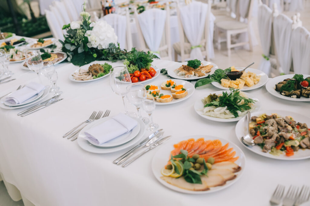 Decorated wedding table with food, drink, appliances and flowers