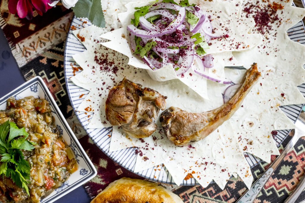 top view tika kebab on pita bread with onions and salad